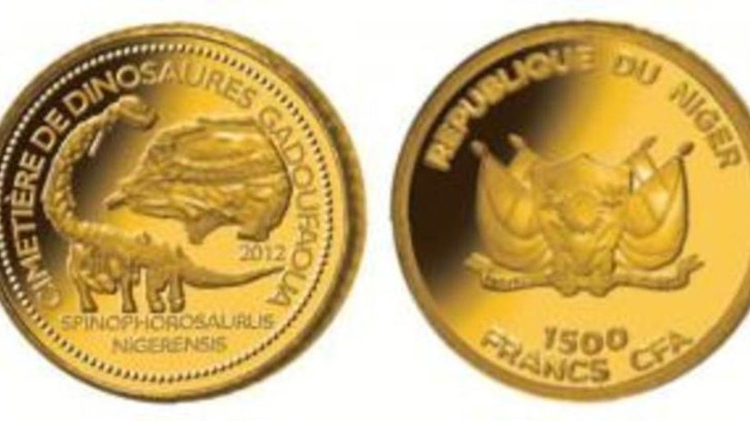 Золотая монета с изображением скелета динозавра
